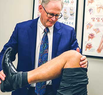 Mark Miller examining bent knee